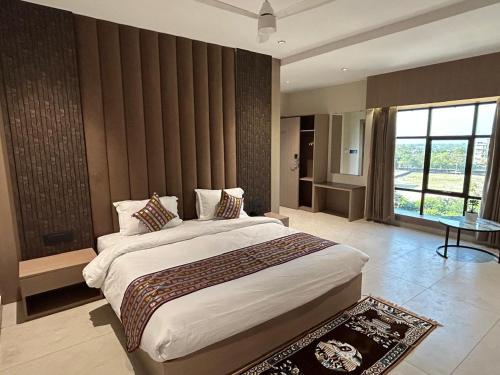 a bedroom with a large bed and a large window at Hotel The Royal Keshar-Near Bhutan Border in Jaigaon