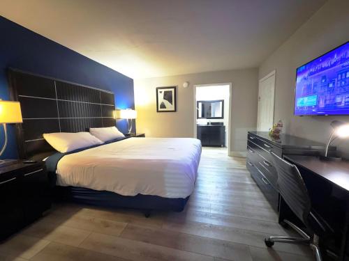 een slaapkamer met een groot bed en een flatscreen-tv bij Boardwalk Suites Lafayette in Lafayette