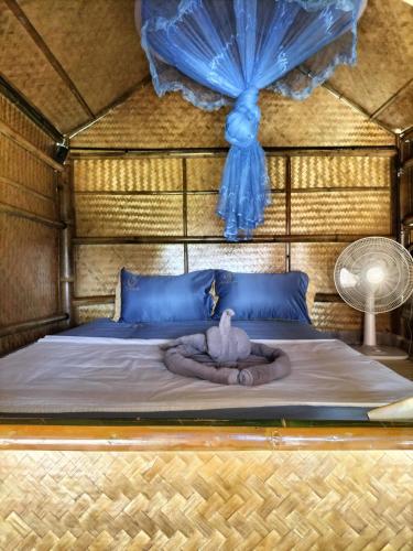 a bedroom with a bed with a swan on it at Shah Hill Hut in Phra Ae beach