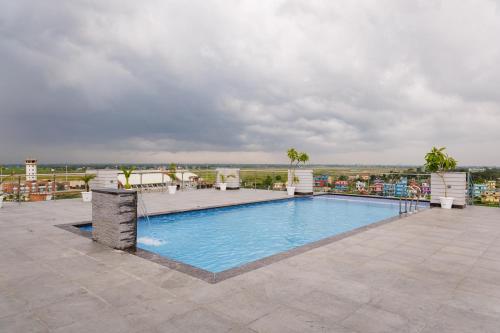Buddha Regency Hotel في Gautam Buddha International Airport: مسبح على سطح منتجع