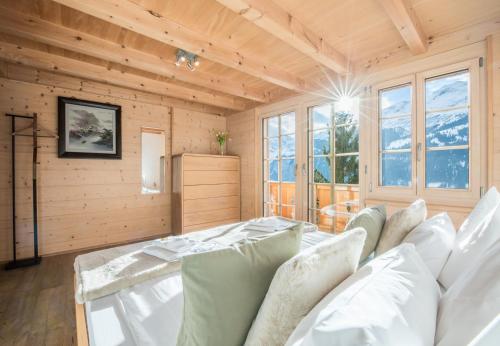 a room with a bed and some windows at Chalet Aberot in Wengen