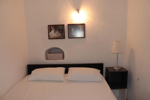 a bedroom with a bed and two pictures on the wall at Bougainvillea in Andros