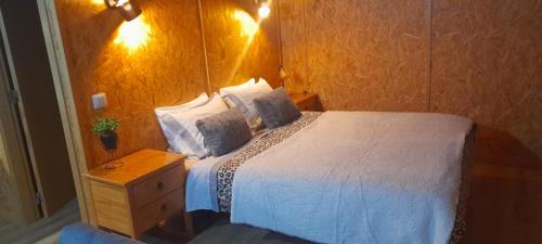 Un dormitorio con una cama blanca y una pared de madera. en Quinta da Bolota Guest House, en Alvaiázere