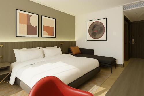 a bedroom with a large bed and a red chair at Ramada by Wyndham Arnavutkoy in Istanbul