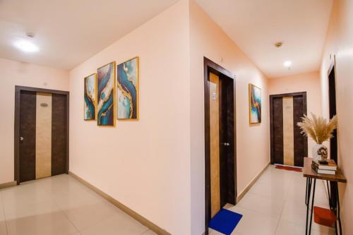 a hallway with doors and paintings on the walls at FabHotel Prime Rockstar Suites in Kolkata