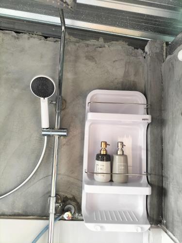 a bathroom with a toilet with two bottles on it at Shah Hill Hut in Phra Ae beach