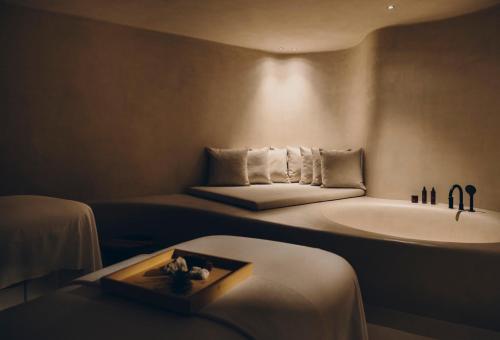 baño con bañera, cama y lavamanos en Forestis Dolomites, en Bresanona