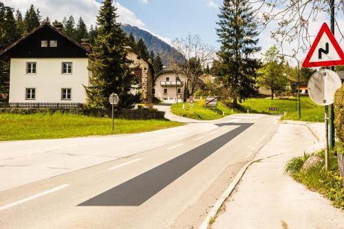 an empty road in a village with a yield sign at Haus Sieben - Singer Lydia in Kötschach
