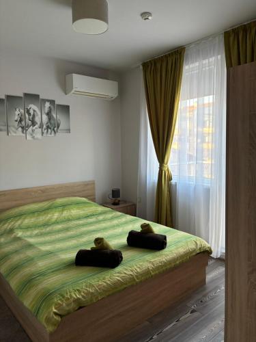 a bedroom with a bed with two teddy bears on it at Апартамент Димана in Hisarya