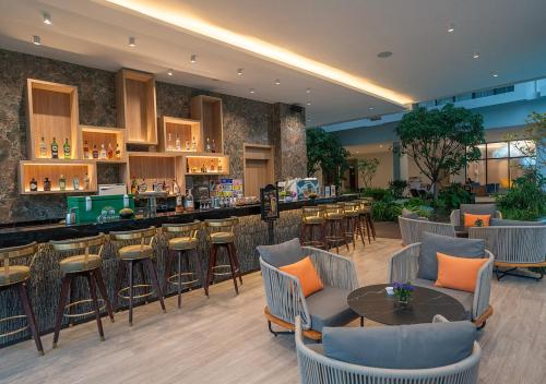 a restaurant with a bar and tables and chairs at Laya Resort Phuket in Layan Beach
