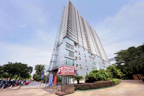 a tall building with a sign in front of it at Prime Pazhou Aparthotel - Pazhou Station Line 8 and 11 - Steps away from Canton Exhibition Center in Guangzhou
