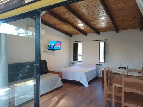 a bedroom with two beds and a tv in it at AIRES DEL BOSQUE Con JACUZZI in Punta Del Diablo