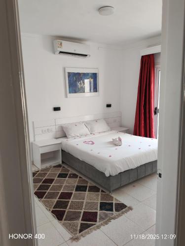 a bedroom with a bed and a red curtain at Elixir Two Bed Rooms in Hurghada