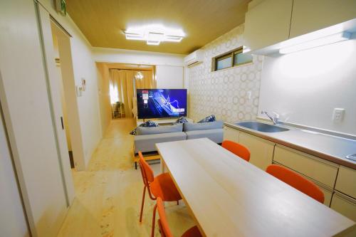 a kitchen with a table and a couch in a room at 京セラドーム大正駅徒歩3分 USJ 大阪観光に便利 CityMaisonDomeFront in Osaka