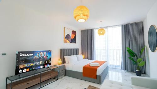 a hotel room with a bed and a flat screen tv at Marina Luxe Escape by Hala Holiday Homes in Ras al Khaimah