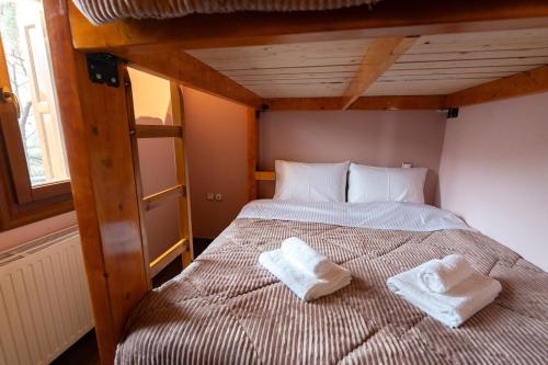 a bedroom with a bed with two white towels on it at Pelion Horizon in Zagora