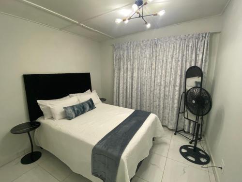 a bedroom with a bed with a fan and a window at 719 Casuarina, Woodgrange on Sea,Hibberdene in Hibberdene