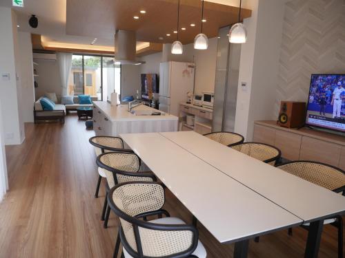 una cucina con un grande tavolo bianco e sedie di 富津 Fun Base a Futtsu