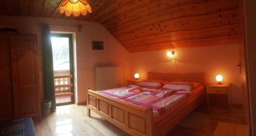 ein Schlafzimmer mit einem Bett in einem Zimmer mit einer Holzdecke in der Unterkunft Farm Stay Juvanija in Solčava