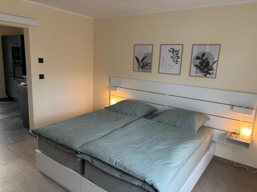 1 cama en un dormitorio con 3 cuadros en la pared en Fewo Hommage, en Spremberg