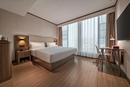 Ένα ή περισσότερα κρεβάτια σε δωμάτιο στο Hanting Hotel Chongqing West Railway Station Square