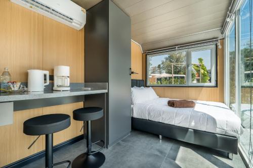 Cozy Nomad Cabin 1 Min Walk to Bang Tao Beach في Ban Lum Fuang: غرفة نوم صغيرة بها سرير ونافذة