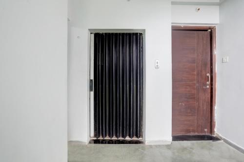 a radiator in a white wall next to a door at Hotel O Wardha Road Near Airport in Nagpur