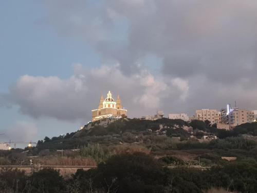 a building on top of a hill in a city at Charming Seaside Apartment in Mellieħa
