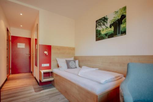 ein kleines Zimmer mit einem Bett und einem Stuhl in der Unterkunft INSIDE Nordhorn by Hackmann in Nordhorn