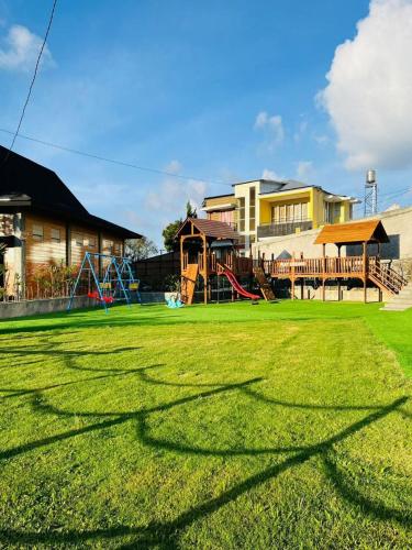 a large yard with a playground and houses at Ndalem Prabu Sarangan in Sarangan