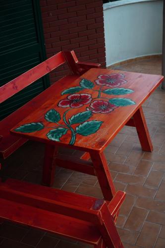 une table en bois avec une fleur peinte dessus dans l'établissement Balkan Hostel, à Tirana