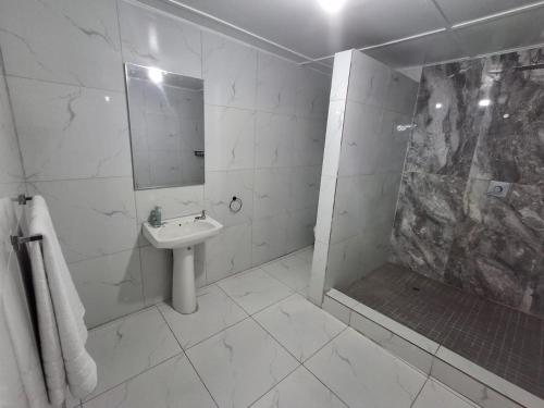 a white bathroom with a sink and a shower at 719 Casuarina, Woodgrange on Sea,Hibberdene in Hibberdene