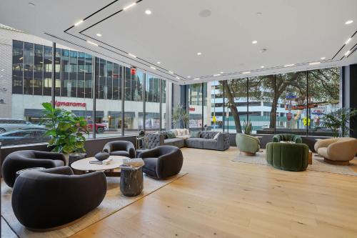 a large lobby with couches and tables and windows at CozySuites Remi sauna, pool, gym in Dallas