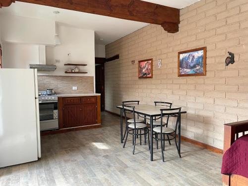Departamento Cafayate في كفايات: مطبخ مع طاولة وكراسي في الغرفة