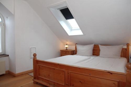 a bedroom with a wooden bed with a skylight at Oberdeck Steuerbord in Greetsiel