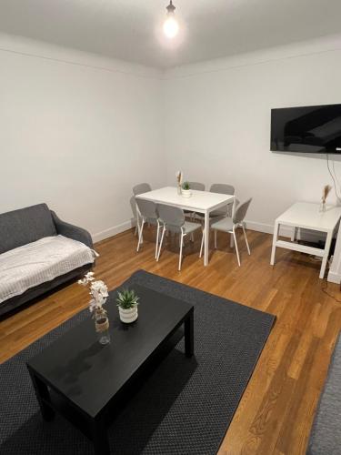 a living room with a couch and a table at Le Toit des Volcans - 8 couchages - Terrasse privée et Wifi in Clermont-Ferrand