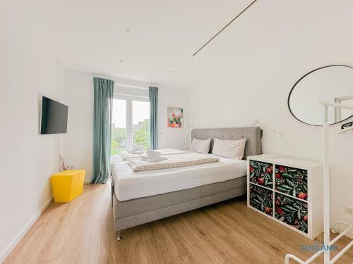 une chambre blanche avec un grand lit et une fenêtre dans l'établissement Ferienhaus am Ringwall 19, à Duhnen