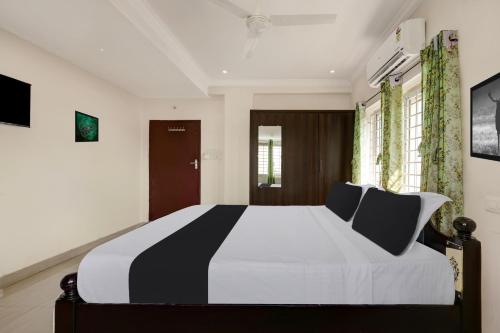 a bedroom with a large black and white bed at Super Hotel O Ramaraopet Near Kakinada Beach in Kākināda