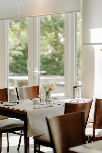 ノルトホルンにあるINSIDE Nordhorn by Hackmannのテーブルと椅子と窓のあるダイニングルーム