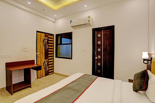 a bedroom with a bed and a desk and a window at Super Collection O Sector 55 Noida Near Noida Stadium in Noida
