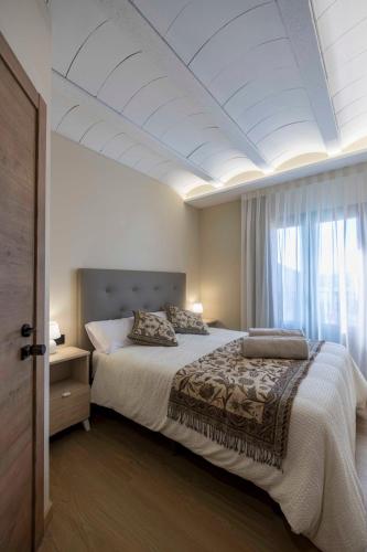 a bedroom with a large bed and a white ceiling at Portal Fosc Suites in Peniscola