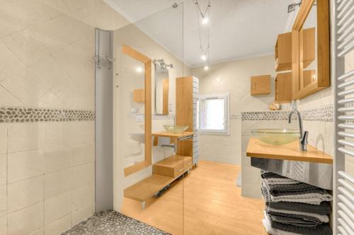 ein Badezimmer mit zwei Waschbecken und einer Glasdusche in der Unterkunft Au bonheur des vacances in Verdun-sur-Garonne