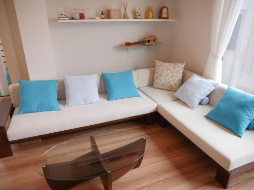 un soggiorno con divano bianco e cuscini blu di 富津 Fun Base a Futtsu