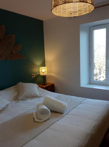 Domaine des Granges : غرفة نوم بسرير ابيض عليها منشفة