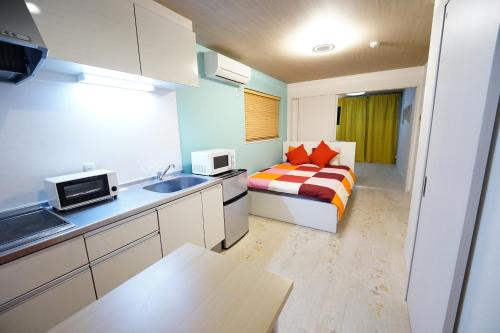 a small room with a bed and a kitchen at 京セラドーム大正駅徒歩3分 USJ 大阪観光に便利 CityMaisonDomeFront in Osaka