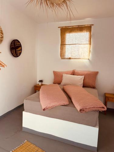 a bedroom with a bed with two pillows and a clock at Surf Sun Sea Lodge in Wassane