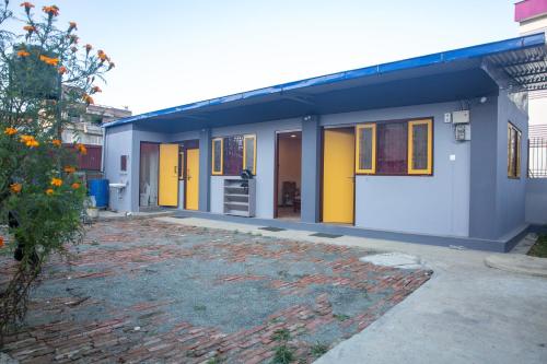 dom z żółtymi drzwiami i podjazdem w obiekcie Sunside Villa w mieście Kirtipur