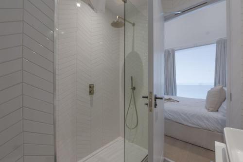 a bathroom with a shower with a glass door at 10 Cannery Row - Stunning Views - Pet Welcome - Free WiFi & Parking in Hayle
