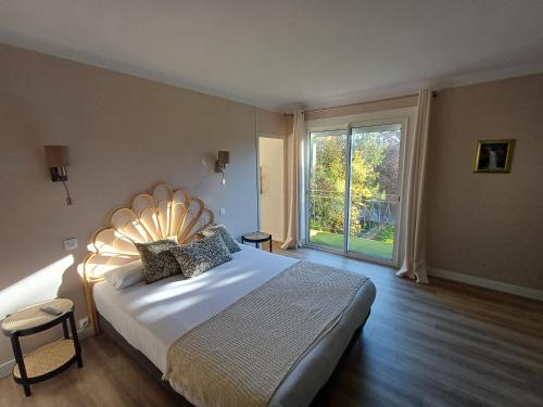 a bedroom with a large bed and a large window at Chez Jade et Zoé in Ortholès
