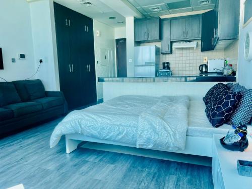 a bedroom with a bed and a kitchen at Panoramic Sea View Studio in Abu Dhabi